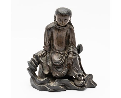 A CHINESE BRONZE FIGURE OF ZHENWUProbably Ming dynasty The Daoist god of the North cast seated wearing loose robes tied at th