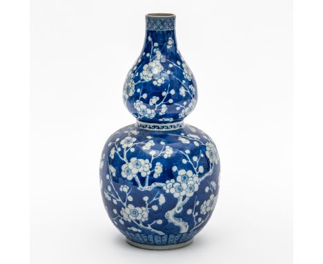 A CHINESE BLUE AND WHITE DOUBLE GOURD VASELate 19th century Painted with prunus on a `cracked ice' ground, apochryphal six ch