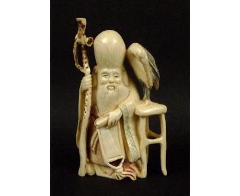 A netsuke, 19th century, of an immortal accompanied by a heron on a stool, signed to base. 