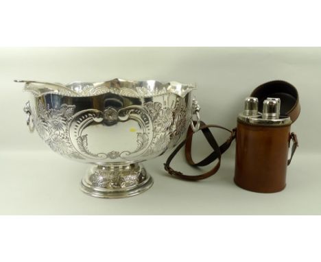 A silver plated punch bowl and ladle, with lions head ring handles, floral embossing on a raised foot, 33 by 20cm, and a trip