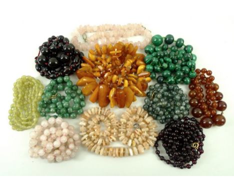 A group of eleven vintage necklaces, dating from the 1920s and later, including malachite, rose quartz, amber, cherry amber r