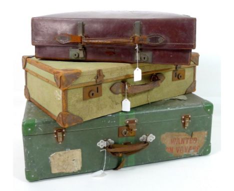 A group of three vintage suitcases, comprising a tin suitcase, a leather case and a linen case with leather corners, largest 