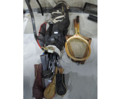 A set of golf clubs and vintage wood framed tennis rackets