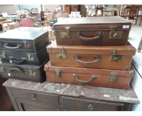 A collection of vintage leather and other suitcases