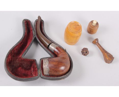 A carved treen pipe tamper, formed as a hand, a silver mounted pipe, in fitted case, a turned wood barrel-shaped box and othe