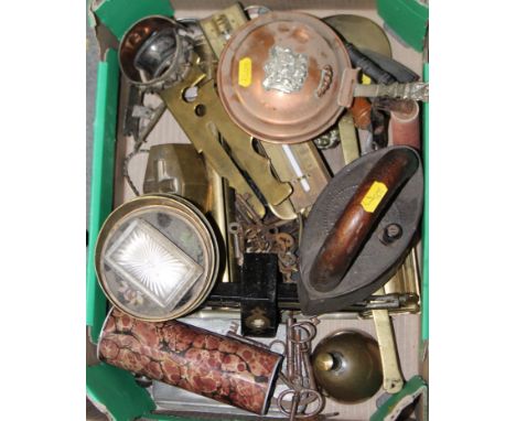 An assortment of metalware, including a coffin-shaped brass box, a servant's bell, a jam thermometer, irons, and other items 