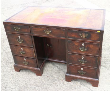 A late 19th century mahogany double pedestal kneehole desk with tool lined top over nine drawers with later brass handles and