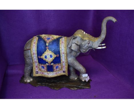 A large ceramic figure study of an Indian elephant dressed in ceremonial robes well detailed no visible damage