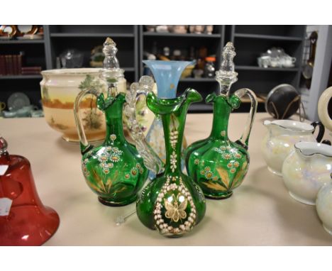 A selection of green glass decanters having decorative enamel work of flowers and butterfly with similar vase