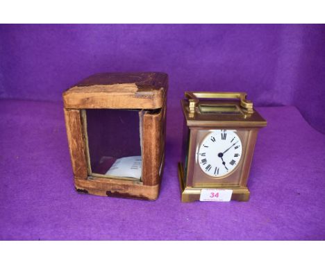 A brass cased carriage clock having a French movement with visible escape and oval enamel clock face.
case contains key and a