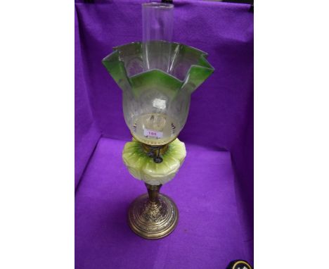 A fine Victorian oil burning lamp by Eltex having brass embossed base with milk glass well and green etched and shaped shade
