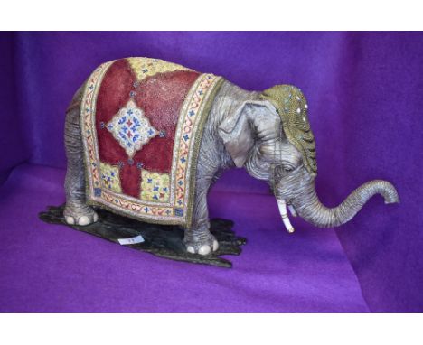 A large ceramic figure study of an Indian elephant dressed in ceremonial robes well detailed no visible damage height approx 