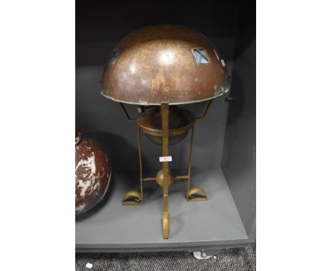 An arts and crafts oil lamp having heavy brass hammered four footed stand with matching hammer finish shade with four blue gl