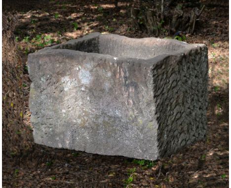 A substantial rough hewn red sandstone trough or planter, probably 18th century, of rectangular form, pierced with a drainage