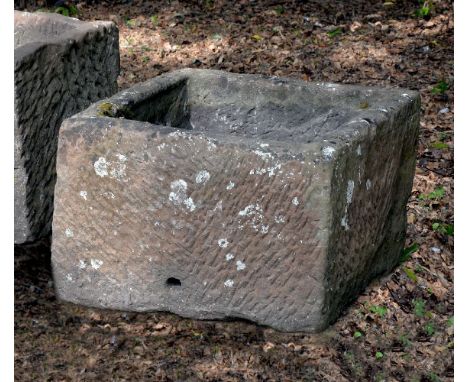 A substantial rough hewn red sandstone trough or planter, probably 18th century, of rectangular form, pierced with a drainage