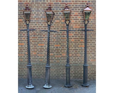 A set of four cast and painted aluminium lamp posts, late 20th century, each with a glazed and copper lantern above a crossba