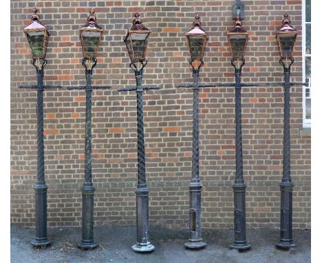 A set of six cast and painted aluminium lampposts, late 20th century, each with glazed copper lantern above a crossbar, on wr
