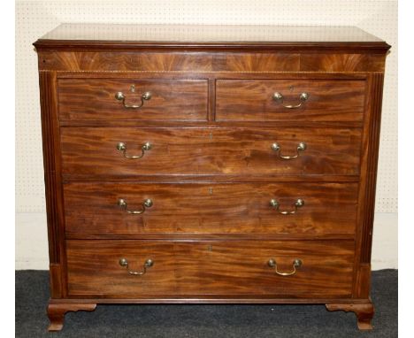 A late George III mahogany and line inlaid chest of two short and three long drawers fitted with ogee brass handles, raised o