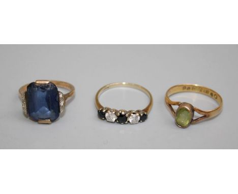 A trio of dress rings to include an 18ct gold hallmarked peridot set ring , size O, 9ct gold cubic zirconia and sapphire half