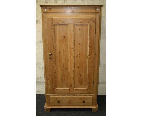 A reclaimed pine single wardrobe of small proportions, the moulded cornice over panel door enclosing hanging rail and pegs, o