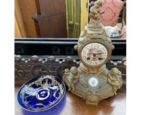 A 19th century French ormolu mantle clock, mounted with cherubs, with a porcelain dial painted to the centre with a winged ch