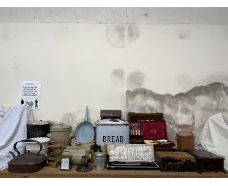 A brass carriage timepiece together with an enamel bread bin, stoneware foot warmers, brass flat irons, cases of part flatwar