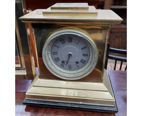 A 19th century brass mantle clock, with a stepped rectangular top with a silvered dial and Roman numerals above a stepped bas