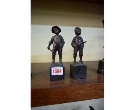 A pair of Continental bronze figures of boys, each on marble socle, 16cm high. 