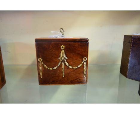 A George III mahogany and inlaid square tea caddy, the hinged top decorated with two inlaid pipes, the front with ivory swags