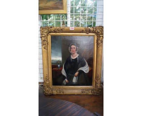English School, 19th century, a three-quarter length portrait of a seated lady wearing a floral bonnet, beside a window with 