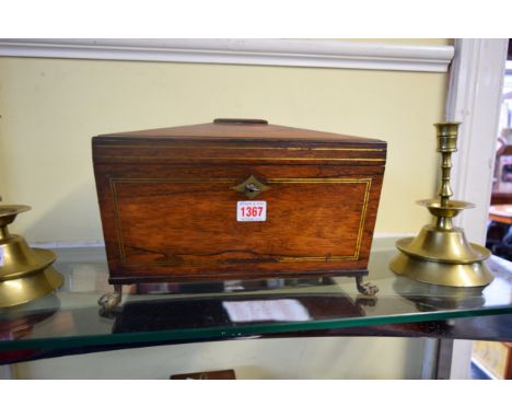 A Regency rosewood and brass strung sarcophagus tea caddy, on cast brass paw feet, 33cm wide.