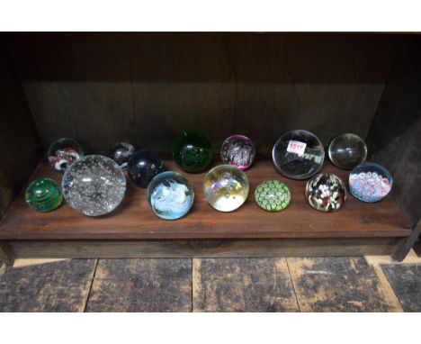 A collection of glass paperweights, to include examples by Caithness.