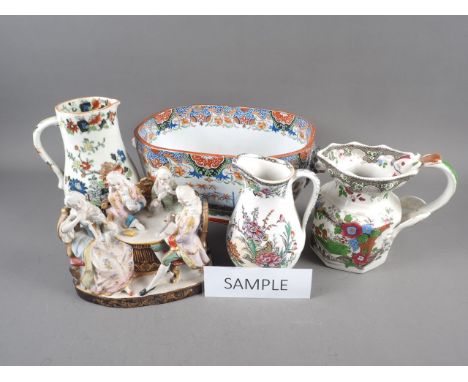 A quantity of ceramic jugs, a porcelain figure group of people playing cards, and a tureen base 