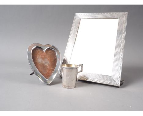 A Goldsmiths and Silversmiths silver photo frame with engine turned decoration, 6 1/2" x 4 3/4", a heart-shaped photo frame a