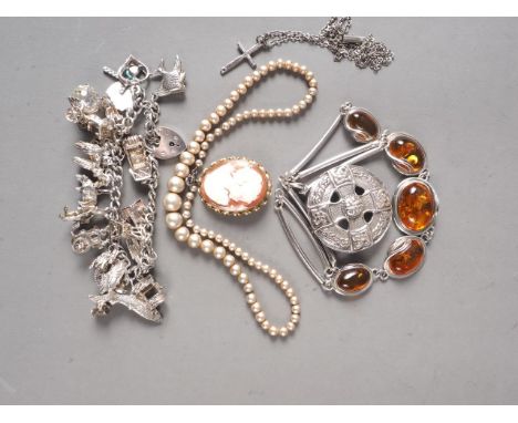 A 9ct gold framed cameo brooch, a silver charm bracelet, a Scottish silver brooch, a silver and amber necklace and two other 