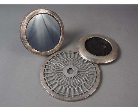 A glass and silver clad kettle stand and two circular silver photo frames 