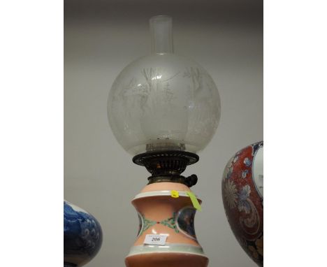 A late 19th century porcelain oil lamp with figure decorated panel, etched shade and chimney, 19" high, a&nbsp;Victorian enam