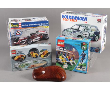 A Lego racer with pullback motor, a Lego football stadium 3403, two scale model racing car kits and a carved wood cat 