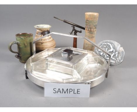 An Art Deco stainless steel and glass lazy Susan, a scale model refracting telescope, studio pottery, a relief erotic plaque,