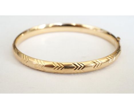 TEN CARAT GOLD BANGLE
with engraved chevron effect decoration, approximately 7.5 grams