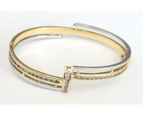 CZ SET FOURTEEN CARAT GOLD BANGLE
the yellow and white gold bangle of asymmetrical design, approximately 13.9 grams
