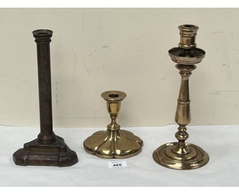 A bronze candlestick, 10¾" high and two brass examples.