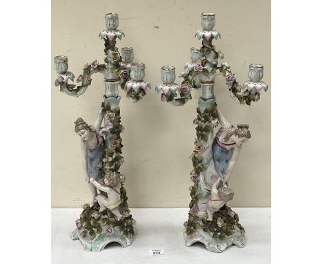 A pair of late 19th Century German porcelain figural four light candelabra, 23" high, with a three light girandole looking gl