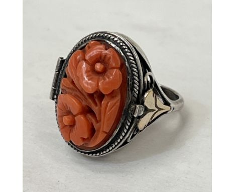 A silver and carved coral locket ring, the back inset with a lock of hair.