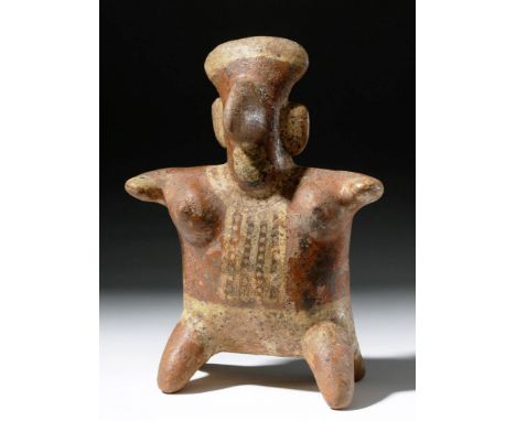 Pre-Columbian, West Mexico, Nayarit, ca. 300 BCE to 300 CE. A female bichrome terracotta figure perched upon a stool, the hol