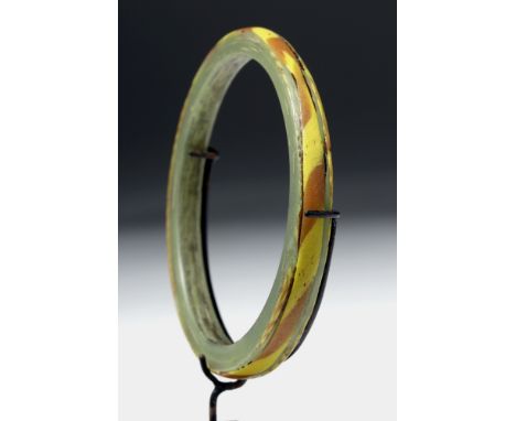 Roman to Byzantine Empires, ca. 5th to 7th century CE. A multi-colored glass bracelet,the bangle comprised of green glass wit