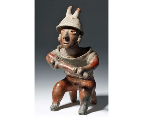 Pre-Columbian, West Mexico, Nayarit, ca. 200 BCE to 250 CE. A male warrior redware pottery figure, seated on a two-legged sto