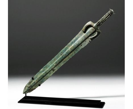Ancient Near East, Luristan, ca. 1000 BCE. A large, well-formed cast bronze sword presenting a long, straight blade with a br