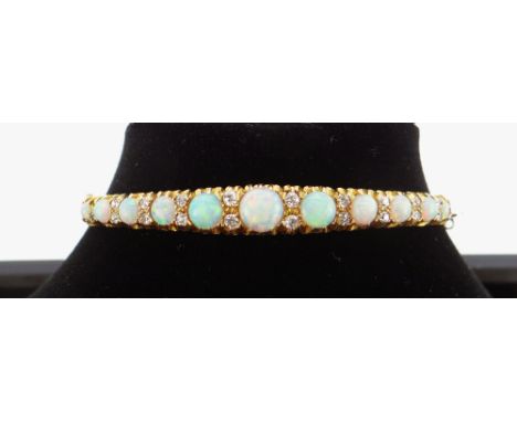 15CT GOLD OPAL & DIAMOND BANGLE, the eleven graduating opals alternating with graduating pairs of diamonds, 13.3gms in W. E W