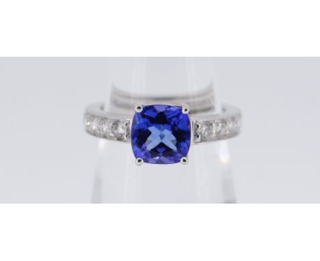 18CT (750) WHITE GOLD TANZANITE &amp; DIAMOND RING, the cushion cut tanzanite (1.61ct approximately) set between sixteen roun